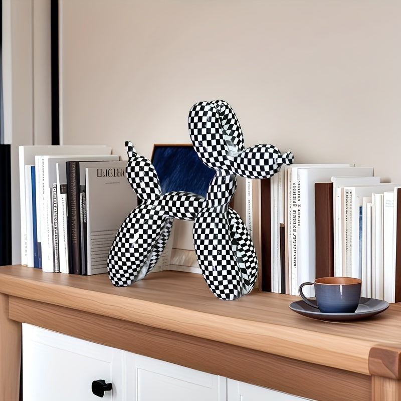 Checkered dog sculpture on a wooden surface with books and a cup in the background