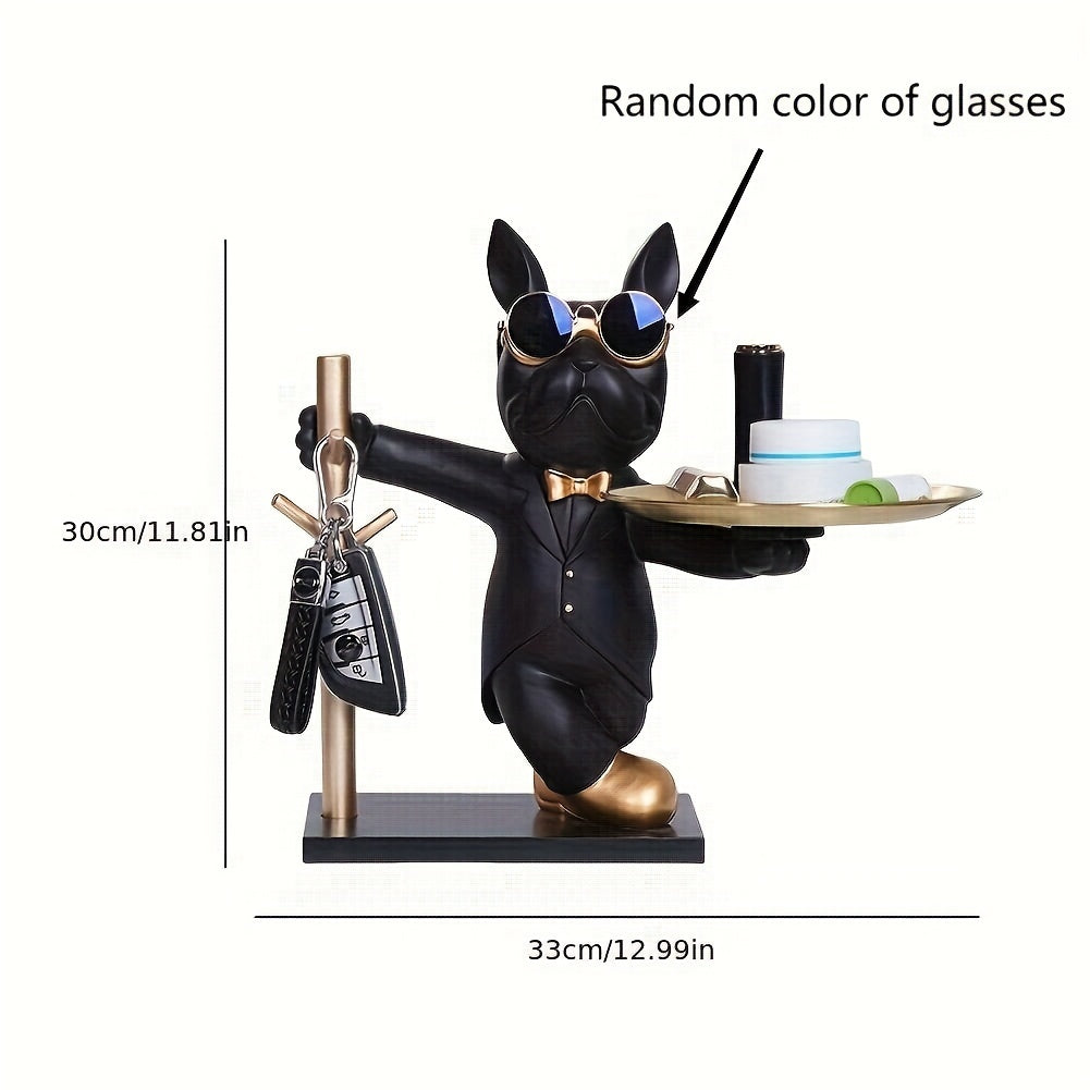 Black dog figurine in a tuxedo with glasses, holding a tray with items, on a white background.