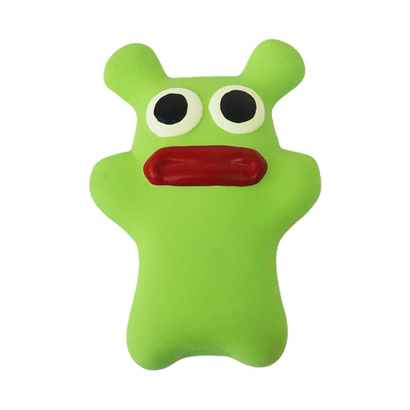 Green rubber toy with googly eyes and a red mouth on a white background