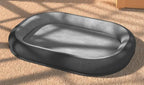 Black pet bed on a beige carpet