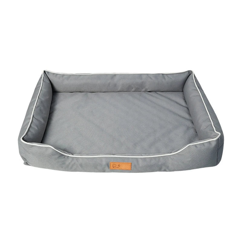 Gray pet bed with white piping on a white background