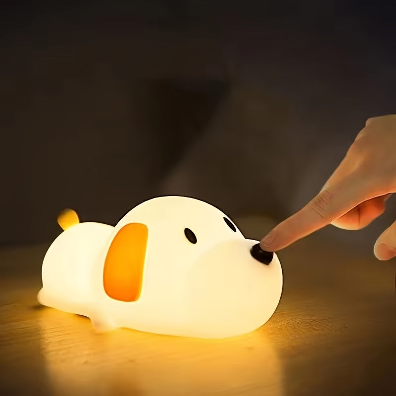 Dog-shaped night light being touched by a hand on a dark background
