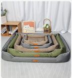 Set of pet beds in green, gray, and beige on a bed with a white curtain background.