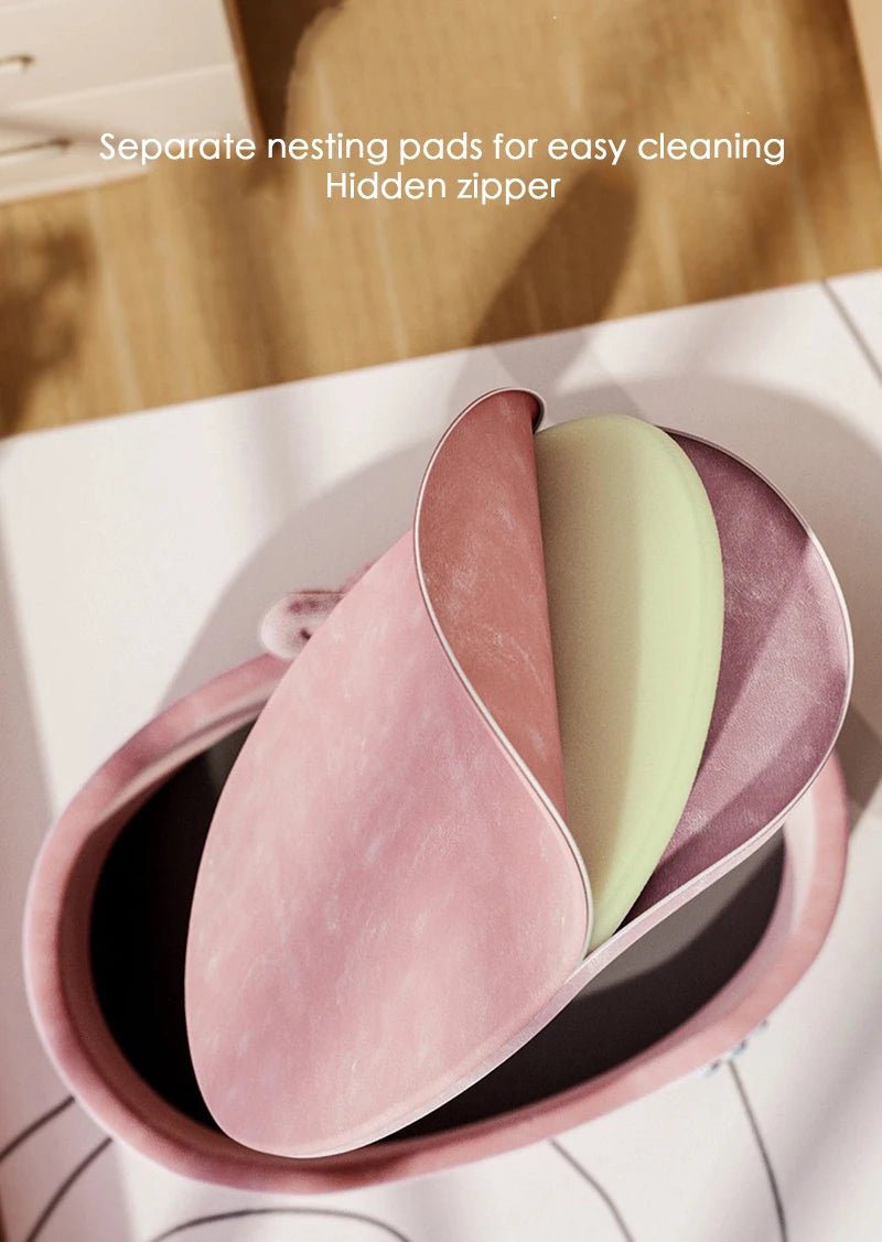 Pink, green, and purple nesting pads in a container with text indicating separate nesting pads for easy cleaning and hidden zipper.